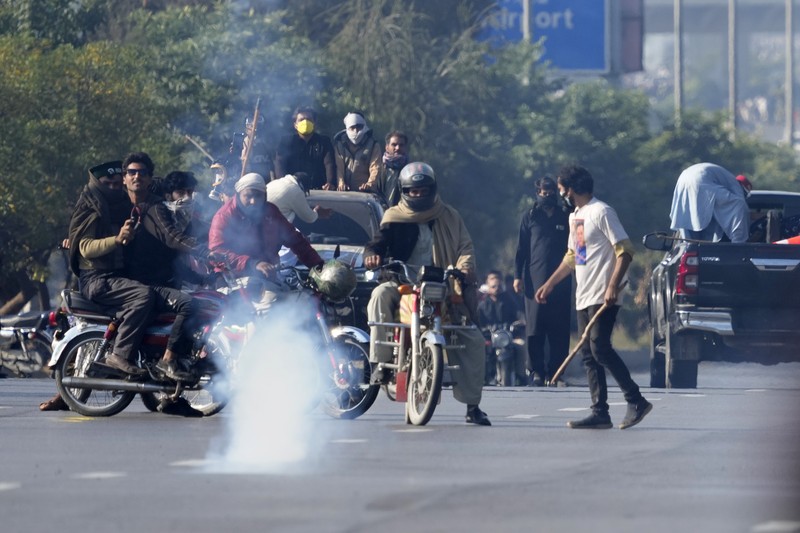 Pendukung mantan Perdana Menteri Imran Khan dari partai Tehreek-e-Insaf Pakistan yang dipenjara melemparkan batu ke arah polisi selama bentrokan di Islamabad, Pakistan, Selasa, 26 November 2024. (AP Photo/Anjum Naveed)