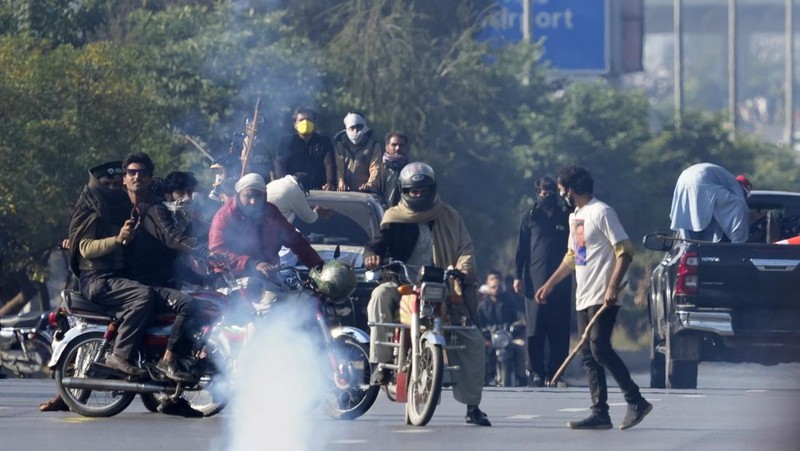 Pendukung mantan Perdana Menteri Imran Khan dari partai Tehreek-e-Insaf Pakistan yang dipenjara melemparkan batu ke arah polisi selama bentrokan di Islamabad, Pakistan, Selasa, 26 November 2024. (AP Photo/Anjum Naveed)