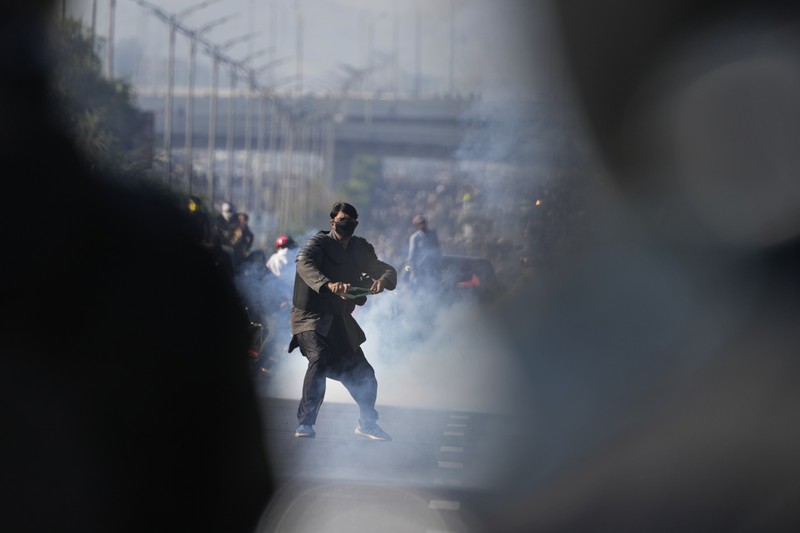Pendukung mantan Perdana Menteri Imran Khan dari partai Tehreek-e-Insaf Pakistan yang dipenjara melemparkan batu ke arah polisi selama bentrokan di Islamabad, Pakistan, Selasa, 26 November 2024. (AP Photo/Anjum Naveed)