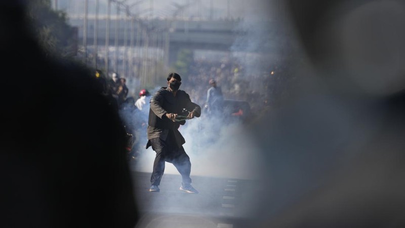 Pendukung mantan Perdana Menteri Imran Khan dari partai Tehreek-e-Insaf Pakistan yang dipenjara melemparkan batu ke arah polisi selama bentrokan di Islamabad, Pakistan, Selasa, 26 November 2024. (AP Photo/Anjum Naveed)