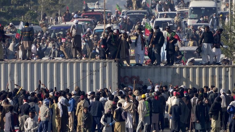 Pendukung mantan Perdana Menteri Imran Khan dari partai Tehreek-e-Insaf Pakistan yang dipenjara melemparkan batu ke arah polisi selama bentrokan di Islamabad, Pakistan, Selasa, 26 November 2024. (AP Photo/Anjum Naveed)