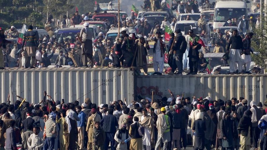 Pendukung partai Pakistan Tehreek-e-Insaf milik mantan perdana menteri Imran Khan yang dipenjara, memindahkan kontainer pengiriman untuk membersihkan jalan bagi unjuk rasa mereka yang menuntut pembebasan Khan, di Islamabad, Pakistan, Selasa, 26 November 2024. (AP Photo/Anjum Naveed)