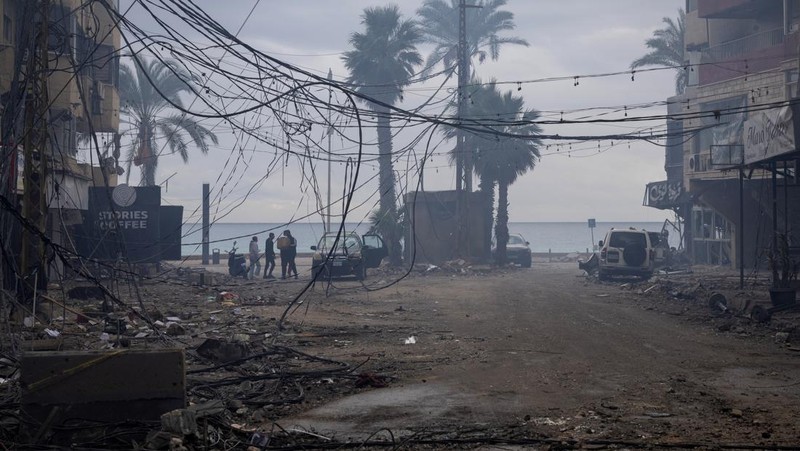 Aya Khater, 15 tahun, dan ayahnya Ibrahim Khater, 51 tahun, membawa barang-barang mereka kembali ke rumah mereka yang hancur, setelah gencatan senjata antara Israel dan kelompok Hizbullah yang didukung Iran mulai berlaku pada pukul 02.00 GMT pada hari Rabu setelah Presiden AS Joe Biden mengatakan kedua belah pihak menerima perjanjian yang ditengahi oleh Amerika Serikat dan Prancis, di Tyre, Lebanon, 27 November 2024. (REUTERS/Adnan Abidi)