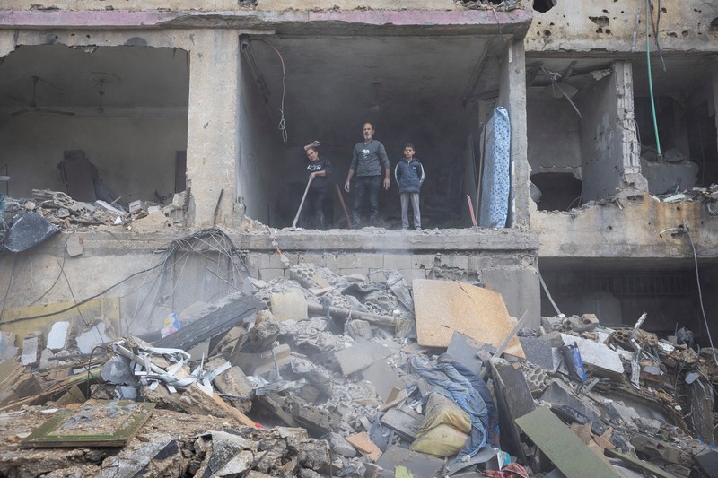 Aya Khater, 15 tahun, dan ayahnya Ibrahim Khater, 51 tahun, membawa barang-barang mereka kembali ke rumah mereka yang hancur, setelah gencatan senjata antara Israel dan kelompok Hizbullah yang didukung Iran mulai berlaku pada pukul 02.00 GMT pada hari Rabu setelah Presiden AS Joe Biden mengatakan kedua belah pihak menerima perjanjian yang ditengahi oleh Amerika Serikat dan Prancis, di Tyre, Lebanon, 27 November 2024. (REUTERS/Adnan Abidi)
