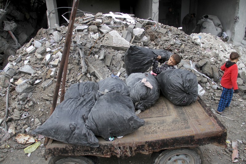 ISRAEL-PALESTINIANS/GAZA A Palestinian boy loads onto a cart items recovered from the rubble at the site of an Israeli attack on a house, during the ongoing conflict between Israel and Hamas, in Gaza City, November 26, 2024. REUTERS/Mahmoud Issa