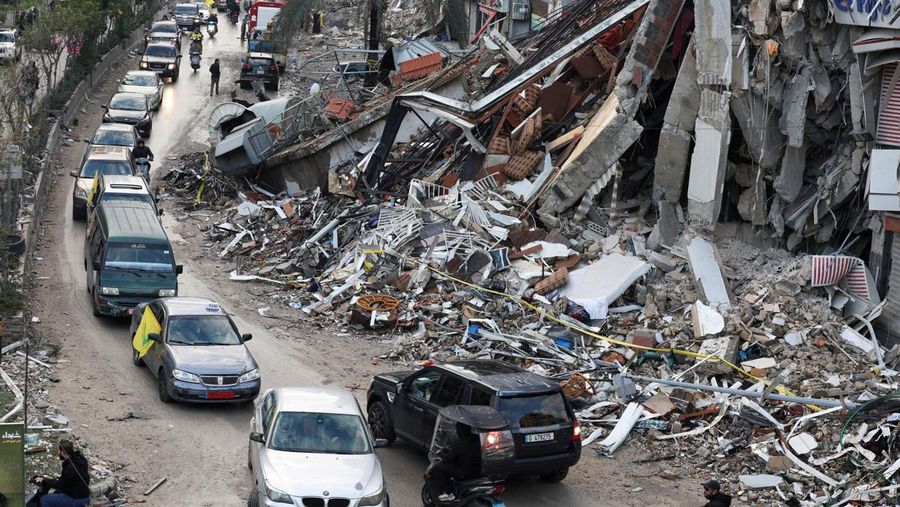 Kendaraan melaju di dekat bangunan yang rusak di pinggiran selatan Beirut, setelah gencatan senjata antara Israel dan Hizbullah berlaku, Lebanon 27 November 2024. (REUTERS/Mohamed Azakir)