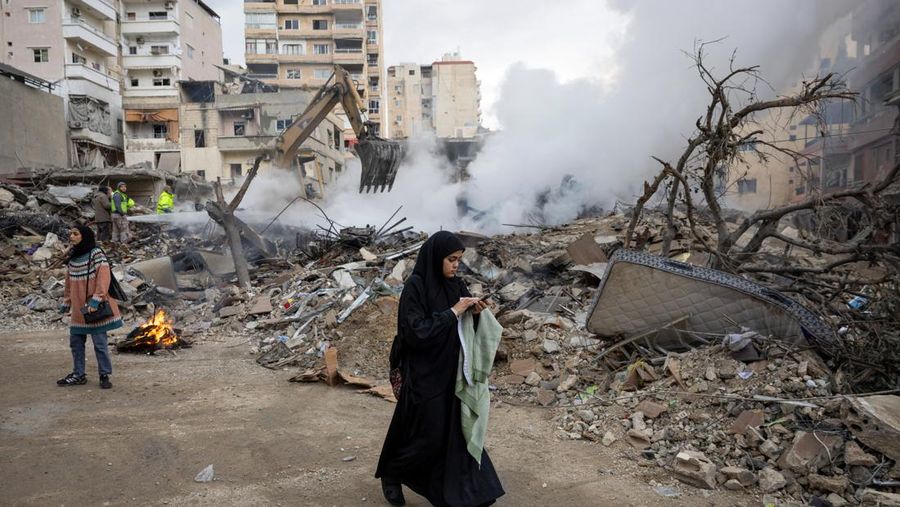 Aya Khater, 15 tahun, dan ayahnya Ibrahim Khater, 51 tahun, membawa barang-barang mereka kembali ke rumah mereka yang hancur, setelah gencatan senjata antara Israel dan kelompok Hizbullah yang didukung Iran mulai berlaku pada pukul 02.00 GMT pada hari Rabu setelah Presiden AS Joe Biden mengatakan kedua belah pihak menerima perjanjian yang ditengahi oleh Amerika Serikat dan Prancis, di Tyre, Lebanon, 27 November 2024. (REUTERS/Adnan Abidi)