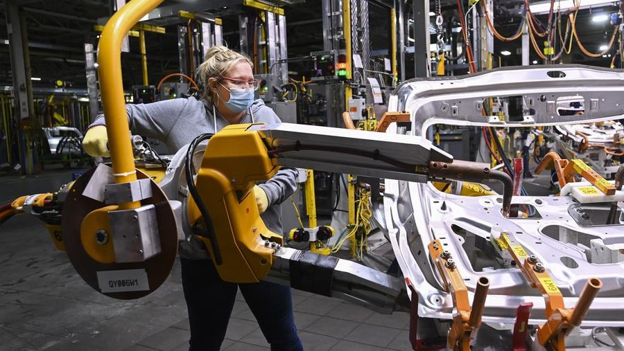 FILE - GM workers use human assistance automation to weld vehicle doors at the General Motors assembly plant during the COVID-19 pandemic in Oshawa, Ontario, March 19, 2021. (Nathan Denette/The Canadian Press via AP, File)