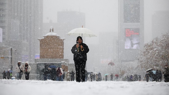 A woman using a smart phone walks during heavy snow fall in central Seoul, South Korea, November 27, 2024.   REUTERS/Kim Hong-Ji
