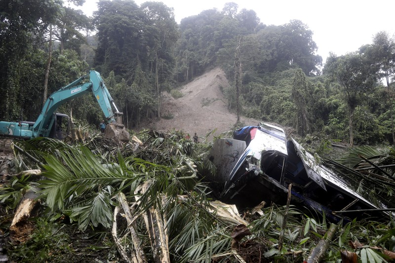 Rescuers remove the body of a victim from the wreckage of a vehicle after it was hit by a landslide that killed multiple people in Deli Serdang, North Sumatra, Indonesia, Thursday, Nov. 28, 2024. (AP Photo/Binsar Bakkara)