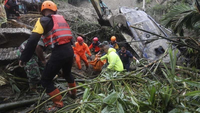 Rescuers remove the body of a victim from the wreckage of a vehicle after it was hit by a landslide that killed multiple people in Deli Serdang, North Sumatra, Indonesia, Thursday, Nov. 28, 2024. (AP Photo/Binsar Bakkara)