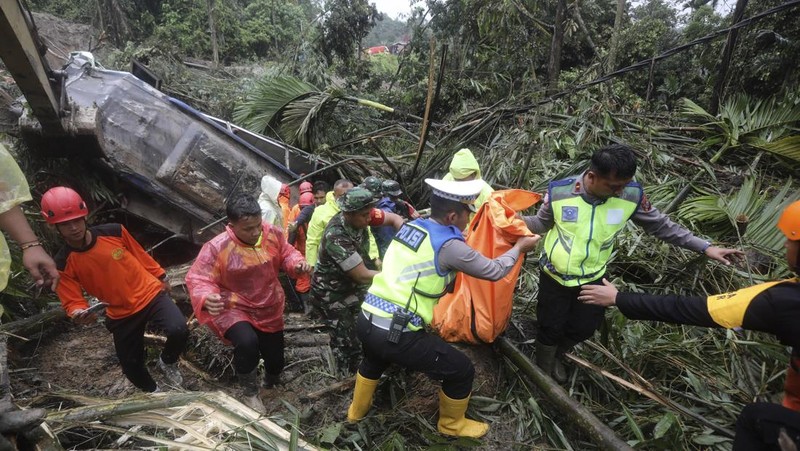 Rescuers remove the body of a victim from the wreckage of a vehicle after it was hit by a landslide that killed multiple people in Deli Serdang, North Sumatra, Indonesia, Thursday, Nov. 28, 2024. (AP Photo/Binsar Bakkara)