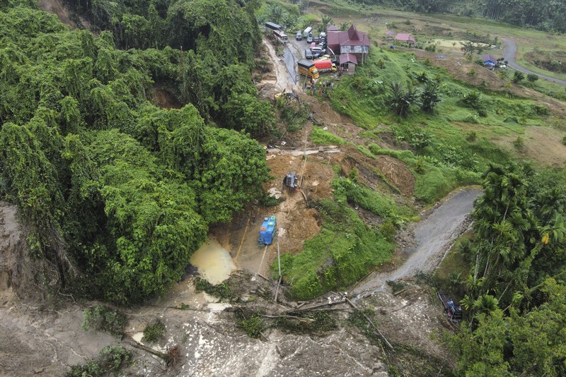 Rescuers remove the body of a victim from the wreckage of a vehicle after it was hit by a landslide that killed multiple people in Deli Serdang, North Sumatra, Indonesia, Thursday, Nov. 28, 2024. (AP Photo/Binsar Bakkara)