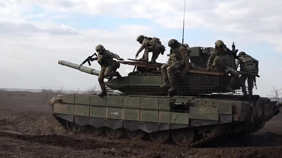 In this photo taken from a video released by Russian Defense Ministry press service on Wednesday, Nov. 27, 2024, Russian servicemen jump off a T-90M Proryv tank during a combat training for assault units in an undisclosed location. (Russian Defense Ministry Press Service via AP)