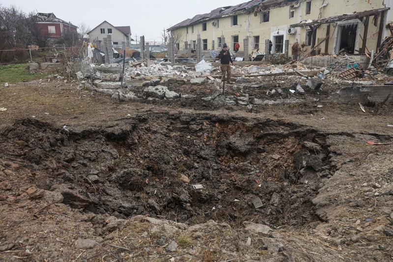 A man films a crater that appeared after a Russian missile strike at residential area, amid Russia's attack on Ukraine, on the outskirts of Odesa, Ukraine November 28, 2024. REUTERS/Nina Liashonok