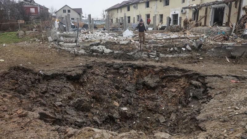 A man films a crater that appeared after a Russian missile strike at residential area, amid Russia's attack on Ukraine, on the outskirts of Odesa, Ukraine November 28, 2024. REUTERS/Nina Liashonok