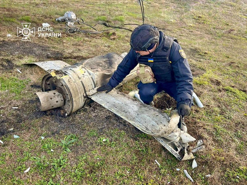 A man films a crater that appeared after a Russian missile strike at residential area, amid Russia's attack on Ukraine, on the outskirts of Odesa, Ukraine November 28, 2024. REUTERS/Nina Liashonok