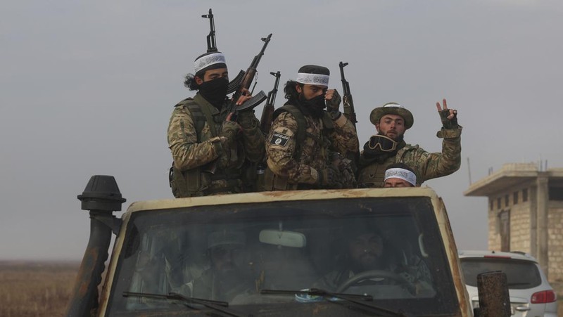 Pemberontak yang dipimpin kelompok militan Islam Hayat Tahrir al-Sham berkendara di sepanjang jalan di al-Rashideen, provinsi Aleppo, Suriah, 29 November 2024. (REUTERS/Mahmoud Hasano)