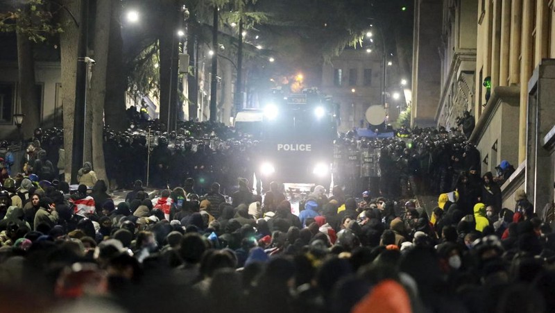 Para demonstran menggunakan petasan terhadap polisi saat polisi memblokir jalan untuk mencegah pengunjuk rasa berunjuk rasa menentang keputusan pemerintah untuk menangguhkan negosiasi untuk bergabung dengan Uni Eropa selama empat tahun, di luar gedung parlemen di Tbilisi, Georgia, Sabtu dini hari, 30 November 2024. (AP Photo/Zurab Tsertsvadze)