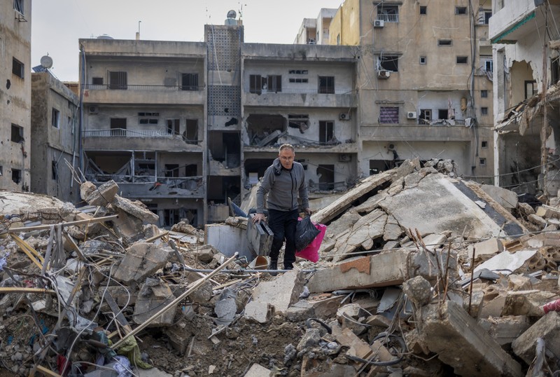 Seorang pria berjalan menuju bangunan yang rusak akibat serangan Israel, di kota Nabatieh, Lebanon selatan, pada hari kedua gencatan senjata antara Israel dan Hizbullah, Lebanon, 28 November 2024. (REUTERS/Adnan Abidi)