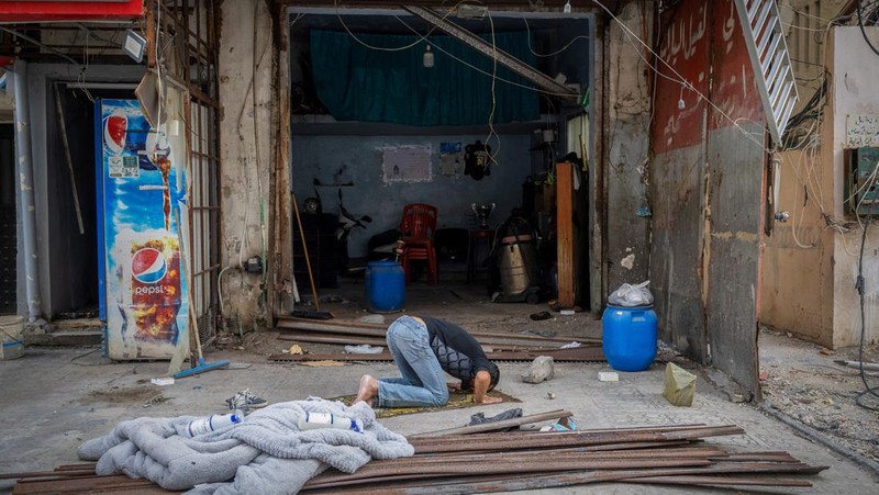 Seorang pria berjalan menuju bangunan yang rusak akibat serangan Israel, di kota Nabatieh, Lebanon selatan, pada hari kedua gencatan senjata antara Israel dan Hizbullah, Lebanon, 28 November 2024. (REUTERS/Adnan Abidi)