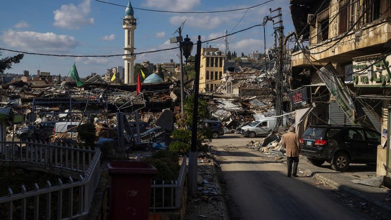 Seorang pria berjalan menuju bangunan yang rusak akibat serangan Israel, di kota Nabatieh, Lebanon selatan, pada hari kedua gencatan senjata antara Israel dan Hizbullah, Lebanon, 28 November 2024. (REUTERS/Adnan Abidi)