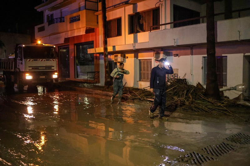 Penduduk setempat mencoba menyelamatkan barang-barang mereka di resor wisata populer Yunani, saat Badai Bora menghantam negara itu untuk hari kedua yang menyebabkan banjir di Ialyssos, Pulau Rhodes, Yunani, 1 Desember 2024. (REUTERS/Stelios Misinas)