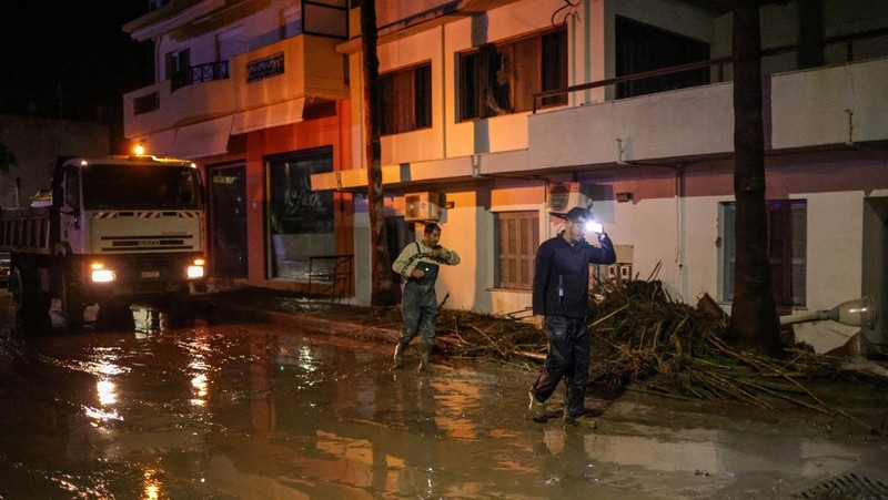 Penduduk setempat mencoba menyelamatkan barang-barang mereka di resor wisata populer Yunani, saat Badai Bora menghantam negara itu untuk hari kedua yang menyebabkan banjir di Ialyssos, Pulau Rhodes, Yunani, 1 Desember 2024. (REUTERS/Stelios Misinas)