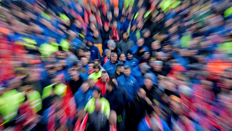 Para pekerja pabrikan mobil asal Jerman, Volkswagen melakukan membawa bendera saat mereka melakukan mogok kerja di Hanover, Jerman, Senin (2/12/2024). (REUTERS/Fabian Bimmer)