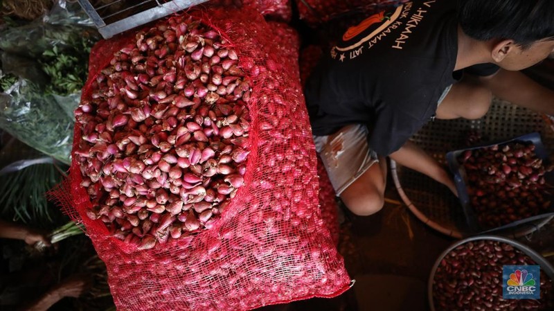 Pekerja menyortir bawang merah yang baru tiba dari Brebes, Jawa Tengah di Pasar Kramat Jati, Jakarta, Senin (2/12/2024). (CNBC Indonesia/Tri Susilo)