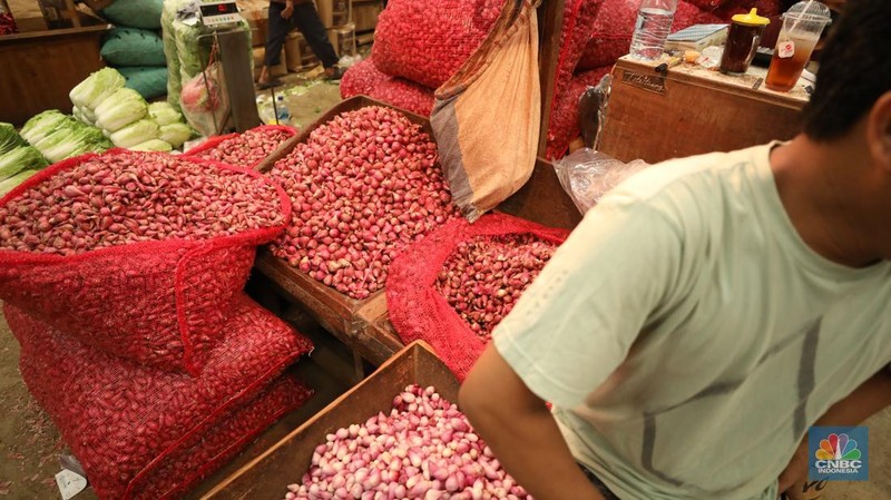 Pekerja menyortir bawang merah yang baru tiba dari Brebes, Jawa Tengah di Pasar Kramat Jati, Jakarta, Senin (2/12/2024). (CNBC Indonesia/Tri Susilo)