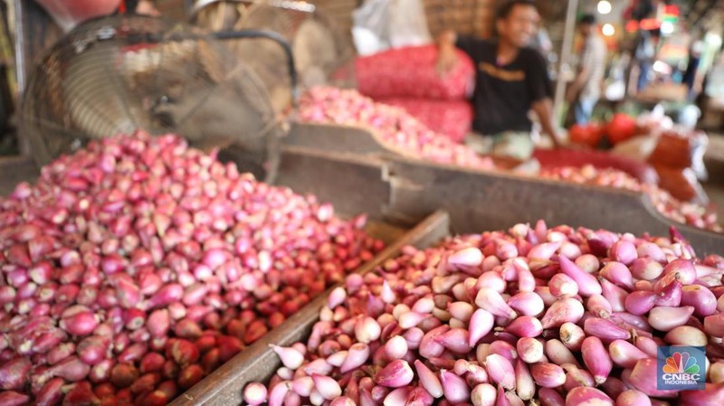 Pekerja menyortir bawang merah yang baru tiba dari Brebes, Jawa Tengah di Pasar Kramat Jati, Jakarta, Senin (2/12/2024). (CNBC Indonesia/Tri Susilo)