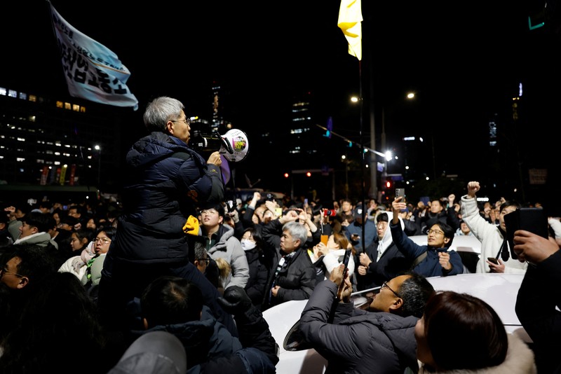 Orang-orang berkumpul di luar Majelis Nasional, setelah Presiden Korea Selatan Yoon Suk Yeol mengumumkan darurat militer, di Seoul, Korea Selatan, 4 Desember 2024. (REUTERS/Kim Soo-hyeon)