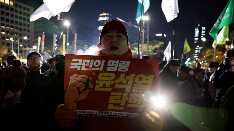 Orang-orang berkumpul di luar Majelis Nasional, setelah Presiden Korea Selatan Yoon Suk Yeol mengumumkan darurat militer, di Seoul, Korea Selatan, 4 Desember 2024. (REUTERS/Kim Soo-hyeon)