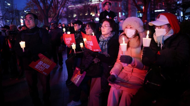 Warga menyalaka lilin saat mengahdiri aksi solidaritas yang mengecam pernyataan mendadak Presiden Korea Selatan Yoon Suk Yeol di Seoul, Korea Selatan, Rabu (4/12/2024). (REUTERS/Kim Kyung-Hoon)