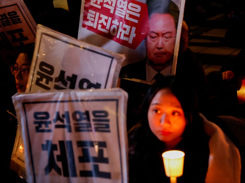 Warga menyalaka lilin saat mengahdiri aksi solidaritas yang mengecam pernyataan mendadak Presiden Korea Selatan Yoon Suk Yeol di Seoul, Korea Selatan, Rabu (4/12/2024). (REUTERS/Kim Kyung-Hoon) Warga menyalaka lilin saat mengahdiri aksi solidaritas yang mengecam pernyataan mendadak Presiden Korea Selatan Yoon Suk Yeol di Seoul, Korea Selatan, Rabu (4/12/2024). (REUTERS/Kim Kyung-Hoon)