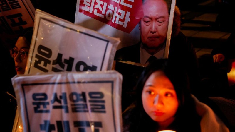 Warga menyalaka lilin saat mengahdiri aksi solidaritas yang mengecam pernyataan mendadak Presiden Korea Selatan Yoon Suk Yeol di Seoul, Korea Selatan, Rabu (4/12/2024). (REUTERS/Kim Kyung-Hoon)