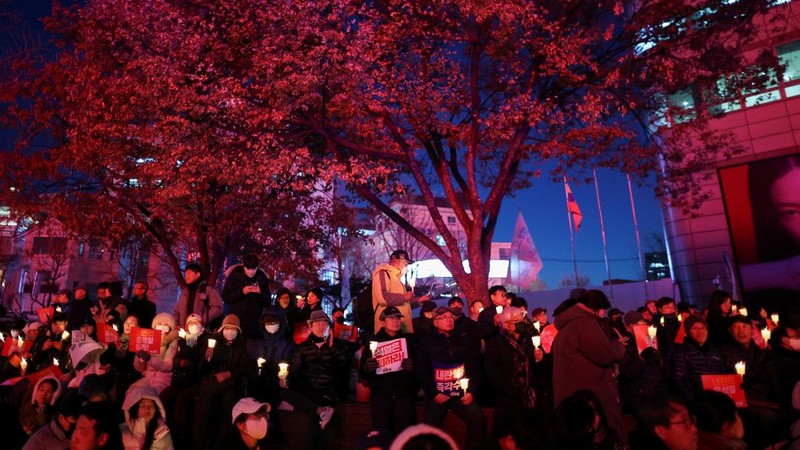 Warga menyalaka lilin saat mengahdiri aksi solidaritas yang mengecam pernyataan mendadak Presiden Korea Selatan Yoon Suk Yeol di Seoul, Korea Selatan, Rabu (4/12/2024). (REUTERS/Kim Kyung-Hoon)