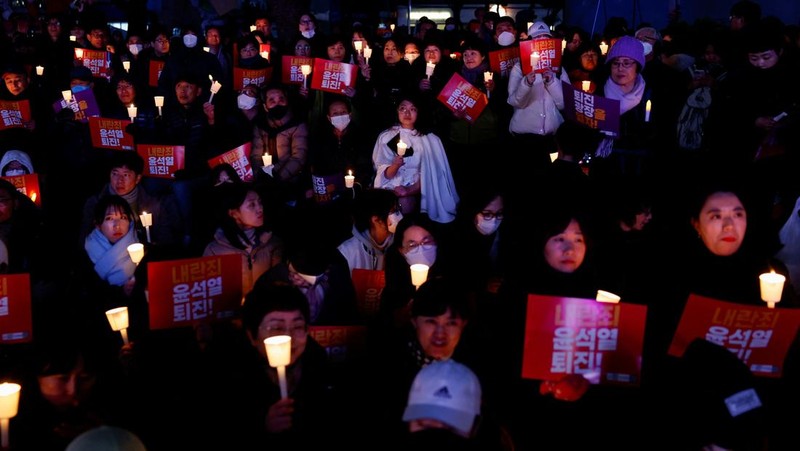 Warga menyalaka lilin saat mengahdiri aksi solidaritas yang mengecam pernyataan mendadak Presiden Korea Selatan Yoon Suk Yeol di Seoul, Korea Selatan, Rabu (4/12/2024). (REUTERS/Kim Kyung-Hoon)