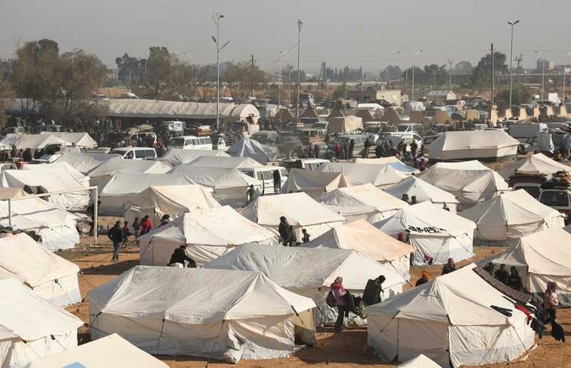 Orang-orang berkumpul di dekat tenda untuk para pengungsi yang melarikan diri dari pedesaan Aleppo, di Tabqa, Suriah, 4 Desember 2024. Orang-orang berkumpul di dekat tenda untuk para pengungsi yang melarikan diri dari pedesaan Aleppo, di Tabqa, Suriah, 4 Desember 2024. (REUTERS/Orhan Qereman)