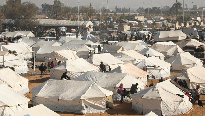 Orang-orang berkumpul di dekat tenda untuk para pengungsi yang melarikan diri dari pedesaan Aleppo, di Tabqa, Suriah, 4 Desember 2024. (REUTERS/Orhan Qereman)