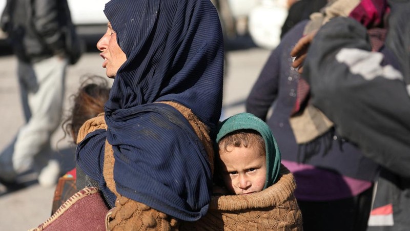 Orang-orang berkumpul di dekat tenda untuk para pengungsi yang melarikan diri dari pedesaan Aleppo, di Tabqa, Suriah, 4 Desember 2024. (REUTERS/Orhan Qereman)