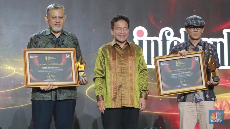 Wakil Ketua Dewan Komisioner OJK Mirza Adityaswara memberi penghargaan kepada Direktur CNBC Indonesia Shanta Curanggana dalam kategori Media Televisi Terproduktif untuk media CNBC Indonesia dalam acara OJK Apresiasi Media Massa 2024 di Hotel Ritz Carlton, Jakarta, Jumat (6/12/2024). (CNBC Indonesia/Muhammad Sabki)