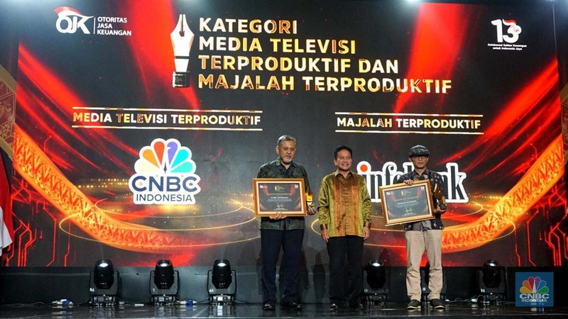 Wakil Ketua Dewan Komisioner OJK Mirza Adityaswara memberi penghargaan kepada Direktur CNBC Indonesia Shanta Curanggana dalam kategori Media Televisi Terproduktif untuk media CNBC Indonesia dalam acara OJK Apresiasi Media Massa 2024 di Hotel Ritz Carlton, Jakarta, Jumat (6/12/2024). (CNBC Indonesia/Muhammad Sabki)