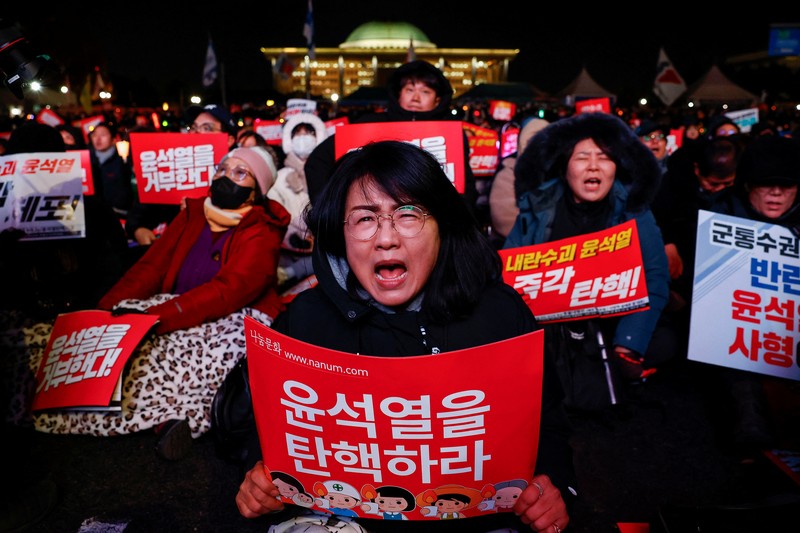 Para pengunjuk rasa meneriakkan slogan-slogan saat unjuk rasa yang menyerukan pemakzulan Presiden Korea Selatan Yoon Suk Yeol, yang mengumumkan darurat militer, yang kemudian dicabut beberapa jam kemudian, di depan Majelis Nasional di Seoul, Korea Selatan, 7 Desember 2024. (REUTERS/Kim Hong-Ji)