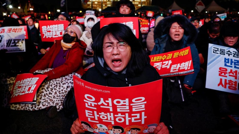 Para pengunjuk rasa meneriakkan slogan-slogan saat unjuk rasa yang menyerukan pemakzulan Presiden Korea Selatan Yoon Suk Yeol, yang mengumumkan darurat militer, yang kemudian dicabut beberapa jam kemudian, di depan Majelis Nasional di Seoul, Korea Selatan, 7 Desember 2024. (REUTERS/Kim Hong-Ji)