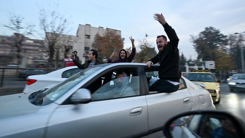 Orang- orang berkumpul di alun-alun utama Damaskus sambil melambaikan tangan dan meneriakkan 'Kebebasan' dari pemerintahan keluarga Assad yang telah berkuasa sekitar 50 tahun. (Photo by LOUAI BESHARA / AFP)