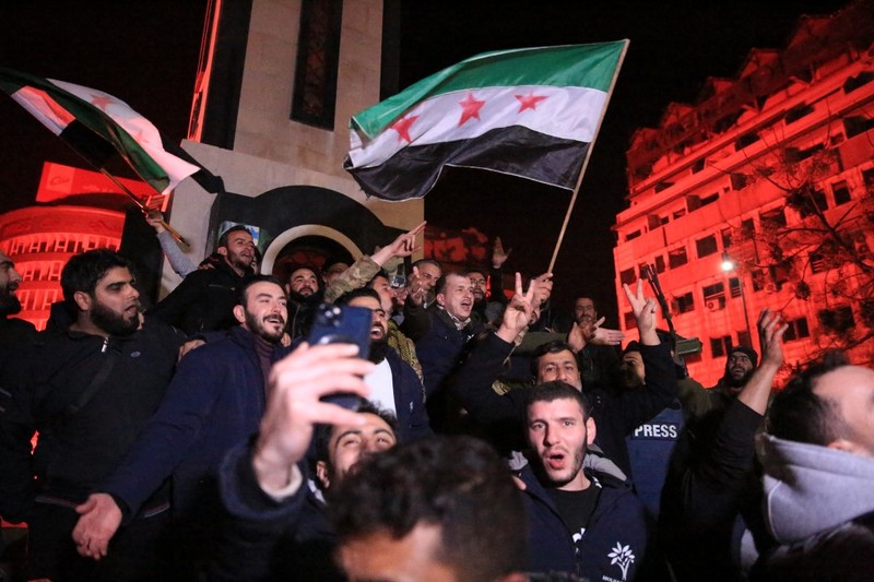 Orang- orang berkumpul di alun-alun utama Damaskus sambil melambaikan tangan dan meneriakkan 'Kebebasan' dari pemerintahan keluarga Assad yang telah berkuasa sekitar 50 tahun. (Photo by LOUAI BESHARA / AFP) Orang- orang berkumpul di alun-alun utama Damaskus sambil melambaikan tangan dan meneriakkan 'Kebebasan' dari pemerintahan keluarga Assad yang telah berkuasa sekitar 50 tahun. (Photo by LOUAI BESHARA / AFP)