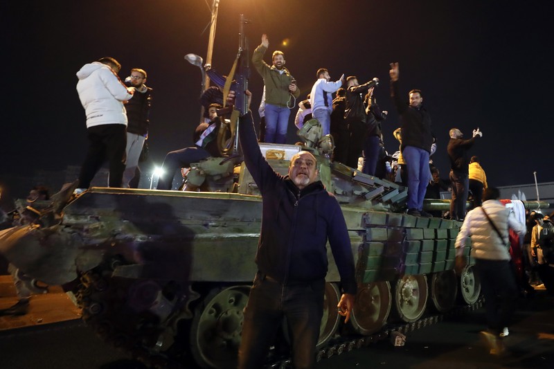 Orang- orang berkumpul di alun-alun utama Damaskus sambil melambaikan tangan dan meneriakkan 'Kebebasan' dari pemerintahan keluarga Assad yang telah berkuasa sekitar 50 tahun. (Photo by LOUAI BESHARA / AFP)