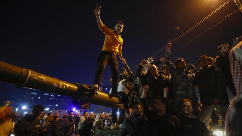 Orang- orang berkumpul di alun-alun utama Damaskus sambil melambaikan tangan dan meneriakkan 'Kebebasan' dari pemerintahan keluarga Assad yang telah berkuasa sekitar 50 tahun. (Photo by LOUAI BESHARA / AFP)